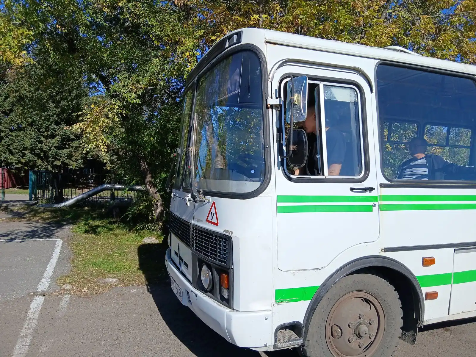 Белый автобус ПАЗ с зелёной полосой и знаком «У» на лобовом стекле