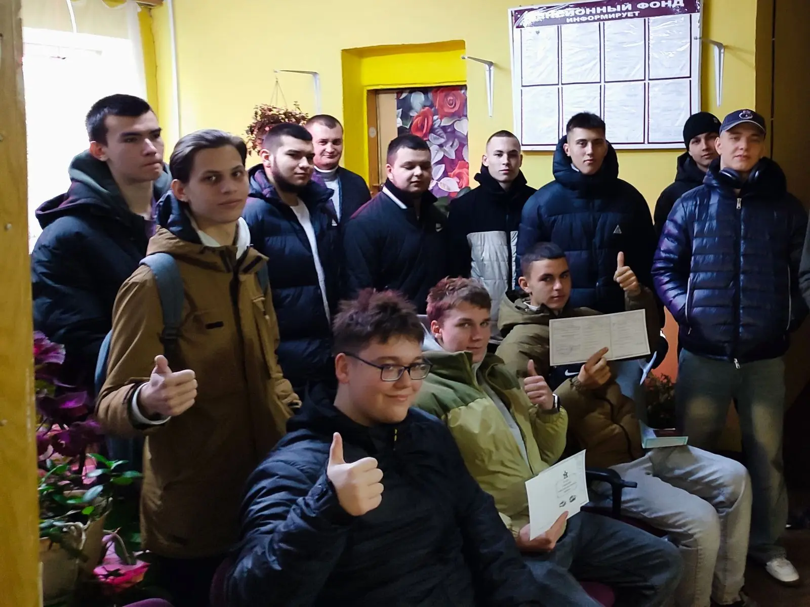 Группа молодых людей со свидетельствами, показывают большой палец